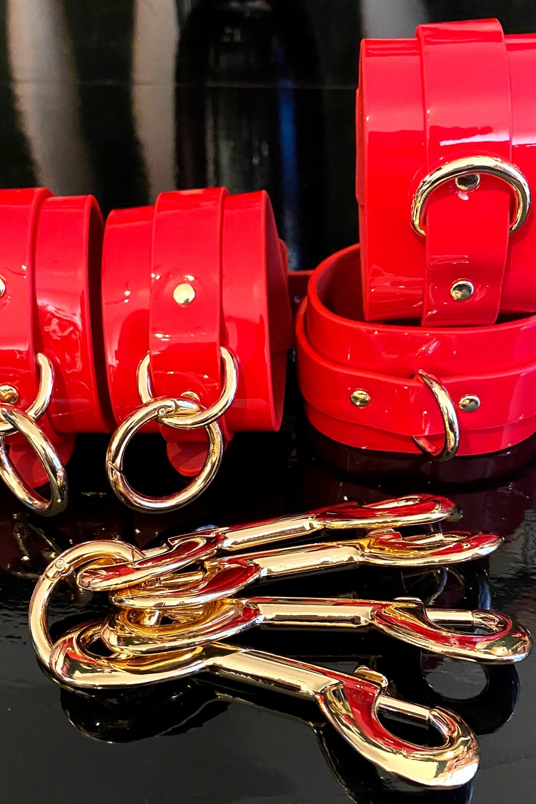 accesoriu fetish BDSM din catuse pentru maini si glezne de culoare rosu lucios si cleme aurii